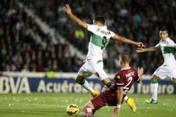 El defensa serbio del Córdoba Aleksandar Pantic comete penalti sobre el delantero del Elche Cristian Herrera (i) durante el partido de la duodécima jornada de liga de Primera División disputado esta tarde en el estadio Martínez Valero. 