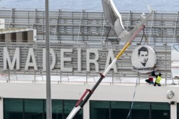 Workers add a sign bearing Cristiano Ronaldo's face to the airport exterior ahead of its 29 March name change to Madeira Cristiano Ronaldo Airport.