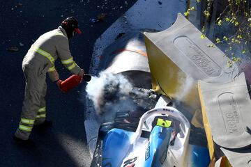 Un bombero apaga el fuego del Williams de Kubica tras chocar contra la protección del muro.