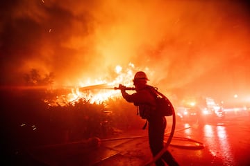 Un bombero lucha contra el incendio de Palisades mientras arde durante una tormenta de viento en el lado oeste de Los ?ngeles.