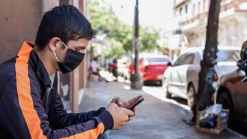 Un hombre con tapabocas utiliza su celular el pasado martes en Asunci&oacute;n (Paraguay). EFE/Nathalia Aguilar