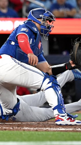Los Angeles Dodgers second baseman Alex Freeland (76) dives home to score a run as Toronto Blue Jays catcher Brandon Valenzuela (59) waits for the throw in the ninth inning at Rogers Centre. Mandatory Credit: Dan Hamilton-Imagn Images