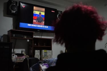 Una mujer observa la pantalla de un televisor público que transmite el discurso a la nación del ministro de Defensa venezolano, Vladimir Padrino. Mientras el presidente estadounidense, Donald Trump, anuncia que el presidente venezolano, Nicolás Maduro, ha sido capturado y está siendo expulsado del país