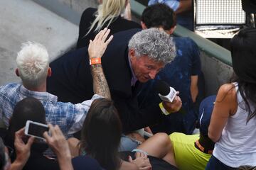 El periodista francés Nelson Monfort sujeta el micro entrevistando al cantante francés M. Pokora en medio de las gradas durante el partido de tenis.