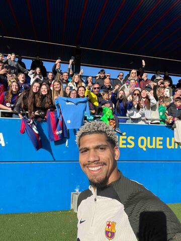 El central uruguayo del F¨²tbol Club Barcelona, Ronald Araujo, se realiza un selfie con los aficionados que se han acercado al entrenamiento.