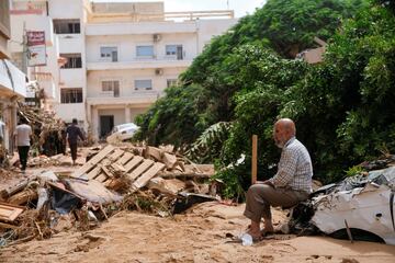 Un hombre sentado en un coche averiado, después de que una poderosa tormenta y fuertes lluvias azotaran Derna.