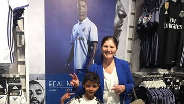 Dolores Aveiro y Cristiano Jr., la madre y el hijo mayor de Cristiano Ronaldo, en posando junto a su póster en una tienda del Real Madrid.