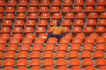 A man sits in the stands during the Africa Cup of Nations (CAN) 2024 group D football match between Algeria and Angola at Stade de la Paix in Bouake 