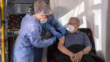 GROSSHARTMANNSDORF, GERMANY - FEBRUARY 21: Nurses Annett Goebel and Bernadett Laub inoculate an elderly resident with the Pfizer/BioNTech Comirnaty vaccine at a mobile vaccination center situated in a modified bus in Grosshartmannsdorf, Germany, February 21, 2021. The state of Saxony is testing several mobile vaccination units, including the converted bus as well as truck-pulled trailers, in an effort to better reach rural communities that might otherwise be far from one of the state's mass vaccination centers. (Photo by Matthias Rietschel/Getty Images)