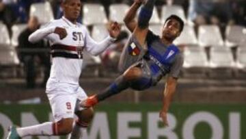  El jugador de Universidad Cat&oacute;lica Hans Mart&iacute;nez patea el bal&oacute;n ante la marca de Luis Fabiano, del Sao Paulo.