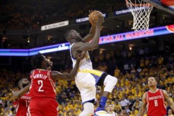 Draymond Green salta hacia la canasta ante Patrick Beverley.
