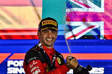 Ferrari's Spanish driver Carlos Sainz Jr sprays champagne as he celebrates on the podium after winning the Singapore Formula One Grand Prix night race at the Marina Bay Street Circuit in Singapore on September 17, 2023. (Photo by Lillian SUWANRUMPHA / AFP)
