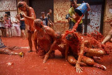BUNOL, SPAIN - AUGUST 30: Revellers enjoy the atmosphere in tomato pulp while participating the annual Tomatina festival on August 30, 2017 in Bunol, Spain. An estimated 22,000 people threw 150 tons of ripe tomatoes in the world's biggest tomato fight held annually in this Spanish Mediterranean town. (Photo by Pablo Blazquez Dominguez/Getty Images)