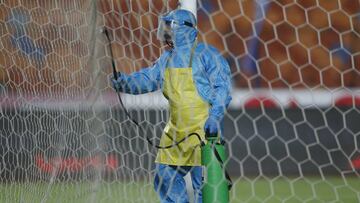 Soccer Football - Egyptian Premier League - Pyramids FC v Al Ahly - Cairo International Stadium, Cairo, Egypt - October 11, 2020 A person wearing protective clothing disinfects the goal posts REUTERS/Amr Abdallah Dalsh