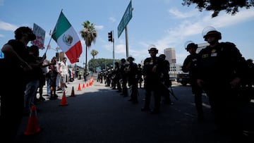 A demonstrator holds a Mexican flag as California Highway Patrol officers stand guard during a No Kings Day protest against President Donald Trump's policies, in Los Angeles, California, U.S., June 14, 2025. REUTERS/Mike Blake