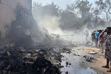 Personas se encuentran entre los escombros en el lugar donde se estrell車 un avi車n en la ciudad de Ahmedabad.