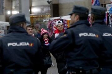 Dispositivo policial ante unos aficionados rojiblancos en el exterior del estadio Vicente Calderón, en Madrid, antes del partido de la decimoquinta jornada de Liga de Primera División entre el Atlético de Madrid y el Villarreal.