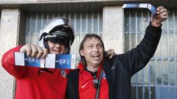 Dos aficionados del Atlético de Madrid muestran las entradas para la final de la Liga de Campeones del 24 de mayo en Lisboa contra el Real Madrid.