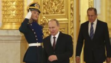 Vladimir Putin (C) seguido por Sergei Lavrov, ministro ruso de Asuntos Exterrores, a su llegada a la ceremonia de presentaci&oacute;n de credenciales de los nuevos embajadores en Mosc&uacute;. 