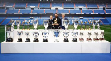 Florentino Pérez, Carlo Ancelotti y Karim Benzema junto con todos los trofeos conseguidos por el delantero francés.