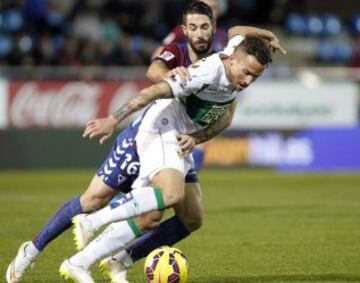 El defensa del Eibar Manuel Castellano "Lillo" (detrás) lucha un balón con Aarón Ñíguez.