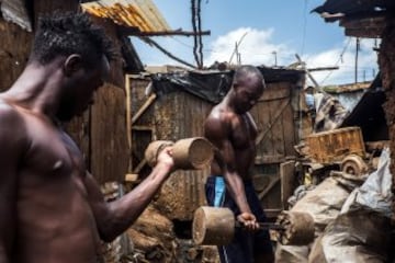 Ben Oloo y Johnstone Mainah entrenan con pesas fabricadas en sus casas en Kibera, Kenia.