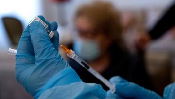 A nurse from the ASL Roma 1 Local Health Authority, prepares to administer a dose of a single-shot Pfizer-BioNTech Covid-19 coronavirus vaccine to Adriana, 91 (Rear), as part of a at-home vaccination campaign for senior citizens carried out by the ASL, on