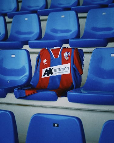 La camiseta está inspirada en la temporada 1995/1996 de la SD Huesca, una etapa marcada por el reciente ascenso a Segunda B y por la lucha del equipo por consolidarse en la categoría. Aquella campaña puso a prueba al club, que respondió compitiendo hasta la última jornada para lograr la permanencia. Treinta años después, la prenda rinde homenaje a aquel momento en el que la SD Huesca reafirmó su identidad basada en el esfuerzo, la humildad y la perseverancia. El diseño conecta aquel equipo que luchaba por abrirse camino con el club actual, recordando el camino recorrido sin perder la esencia que ha definido siempre al Huesca.