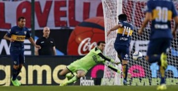 Boca Juniors' Nicolas Lodeiro (R) scores past River Plate's goalkeeper Marcelo Barovero while teammate Carlos Tevez (L) watches during their Argentine First Division soccer match in Buenos Aires September 13, 2015. REUTERS/Marcos Brindicci