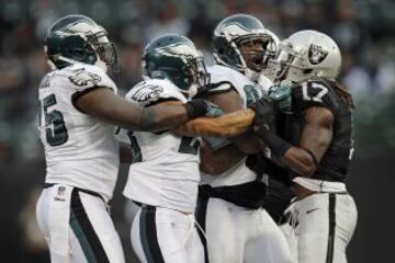 Philadelphia Eagles-Oakland Raiders. Denarius Moore (17) es increpado por Vinny Curry (75), Patrick Chung (23) y Fletcher Cox (91).