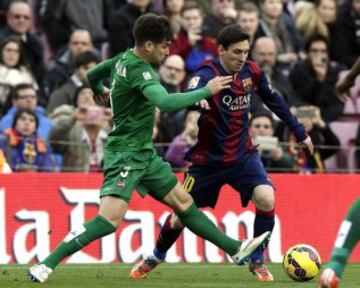 El delantero argentino del FC Barcelona Lionel Messi con el balón ante el defensa del Levante "Toño" García, durante el partido de la vigésimo tercera jornada de liga de Primera División.