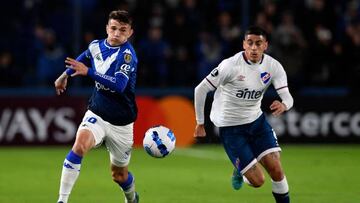 Argentina's Velez Luca Orellano and Uruguay's Nacional Camilo Candido vie for the ball during their Copa Libertadores group stage football match, at the Gran Parque Central stadium, in Montevideo, on May 18, 2022. (Photo by PABLO PORCIUNCULA / AFP) (Photo by PABLO PORCIUNCULA/AFP via Getty Images)