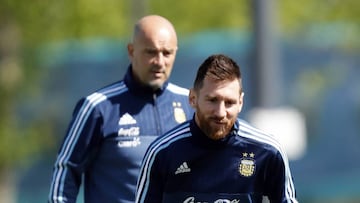 Messi controla un bal&oacute;n ante la mirada de Sampaoli. 