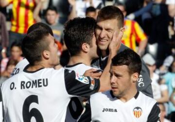 El portero del Valencia, Vicente Guaita (detrás), recibe la felicitación de sus compañeros tras detener un penalty en el partido ante el Elche, de la trigésima tercera jornada de liga en Primera División que se disputa esta tarde en el estadio de Mestalla.