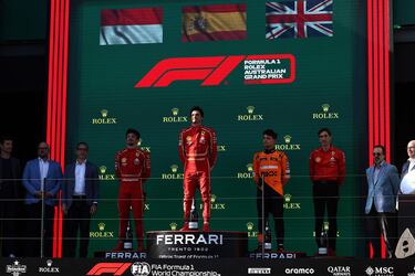 Imagen completa del podio con Carlos Sainz en el escalón central como vencedor de la carrera, a su derecha, su compañero en Ferrari el monegasco Charles Leclerc, y a la izquierda de Sainz, el piloto británico de McLaren Lando Norris que terminó tercero en Australia.
