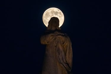 Vista de la luna llena elevándose sobre el Monumento a la Inmaculada Concepción en Sevilla, España.