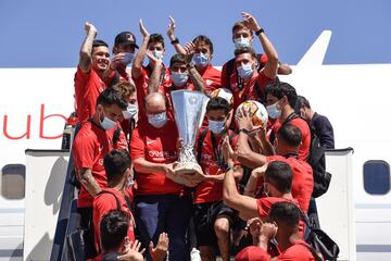 El capitán del equipo, Jesús Navas, junto con el presidente, José Castro Carmona han bajado el ansiado trofeo por las escaleras del avión.