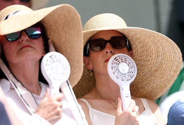 Los espectadores en las gradas de la cancha central usan ventiladores para refrescarse durante el partido de primera ronda entre la checa Barbora Krejcikova y la filipina Alexandra Eala.