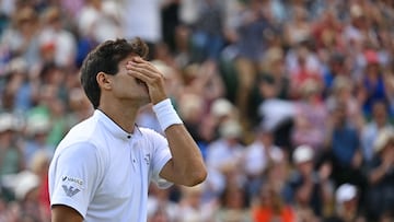 Chile's Cristian Garin celebrates beating Australia's Alex De Minaur (R) during their round of 16 men's singles tennis match on the eighth day of the 2022 Wimbledon Championships at The All England Tennis Club in Wimbledon, southwest London, on July 4, 2022. (Photo by SEBASTIEN BOZON / AFP) / RESTRICTED TO EDITORIAL USE