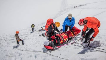 Rescate de la PGHM de la monta&ntilde;a, con el helic&oacute;ptero al fondo.