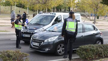 Un agente de la Polic&iacute;a Nacional para un veh&iacute;culo durante un control policial en el segundo d&iacute;a de entrada en vigor de las nuevas restricciones de movilidad en el municipio madrile&ntilde;o de Alcorc&oacute;n, Madrid (Espa&ntilde;a) a