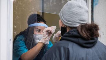 A woman is tested for Covid-19 thgough the window of a doctor's practice in the Kreuzberg neighbourhood in Berlin, on October 21, 2020. (Photo by STEFANIE LOOS / AFP)