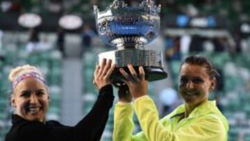 Bethanie Mattek-Sands y Lucie Safarova levantan el trofeo de campeonas del doble femenino en Melbourne.