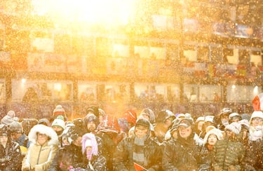 Aficionados del equipo de la República Popular China esperan bajo una intensa nevada durante un retraso previo a la final femenina de Big Air de esquí libre. 
