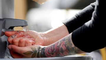 SOMERVILLE, MASSACHUSETTS - MARCH 21: A patron washes their hands at the hand washing station at the entrance of the Safe Supply outdoor grocery store at Bow Market on March 21, 2020 in Somerville, Massachusetts. In order to comply with the city of Somerv