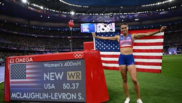 Paris 2024 Olympics - Athletics - Women's 400m Hurdles Final - Stade de France, Saint-Denis, France - August 08, 2024. Sydney McLaughlin-Levrone of United States celebrates with her national flag after winning gold and a new world record. REUTERS/Dylan Martinez