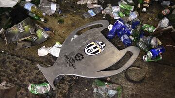 Un cartón del trofeo de la Champions con el escudo de la Juventus entre la basura de la plaza de San Carlo en Turín después de la avalancha.