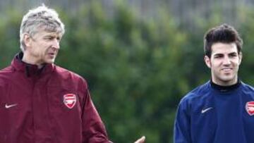 Arsene Wenger charla con Cesc Fábregas durante un entrenamiento del Arsenal.