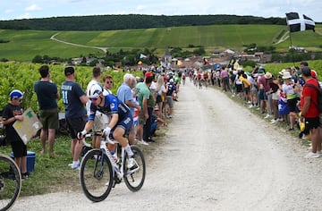 El francés Romain Gregoire de Groupama - FDJ compiten pasando por un sector de gravilla mientras los fanáticos vitorean durante la novena etapa del Tour de Francia.