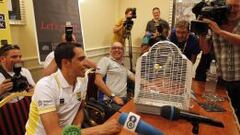 Alberto Contador recibi&oacute; un regalo especial durante la conferencia de prensa: un p&aacute;jaro. Su portavoz, Jacinto Vidarte, sonr&iacute;e ante el presente.